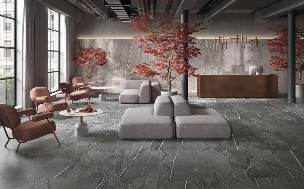 Cercomin posliinilaatat ylellisessä vastaanottotilassa, jossa vaaleanpunaiset tuolit ja harmaat modulaariset sohvat