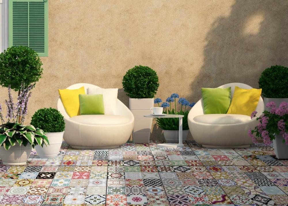 Коллекция керамического гранита Apavisa на террасе: узорчатые плитки, кресла и растения создают уютное открытое пространство.