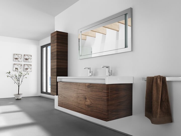 Moderni minimalistinen kylpyhuone, jossa on kaksialtainen allaskaappi ja suuri peili. Suuret ikkunat päästävät sisään luonnonvaloa, korostaen tilavaa ja selkeää muotoilua.