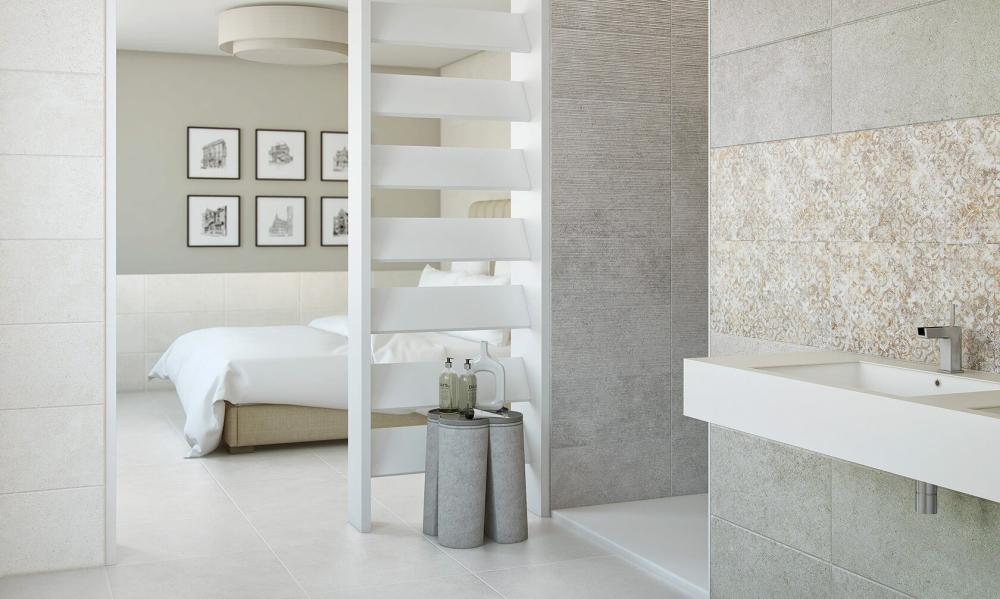 Керамическая плитка Bellacasa в ванной комнате, примыкающей к современной светлой спальне, отделённой белой перегородкой.