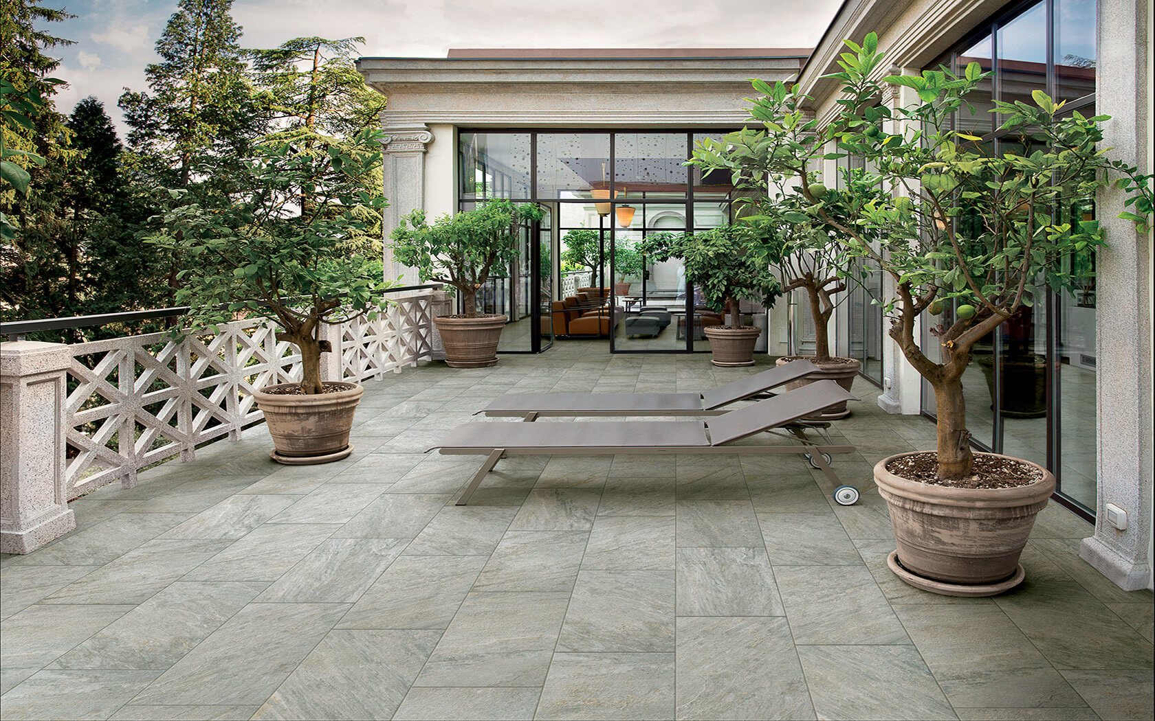 Alfalux Stonequartz Perla hallikad kivimustriga plaadid avatud terrassil rohelusega ümbritsetuna