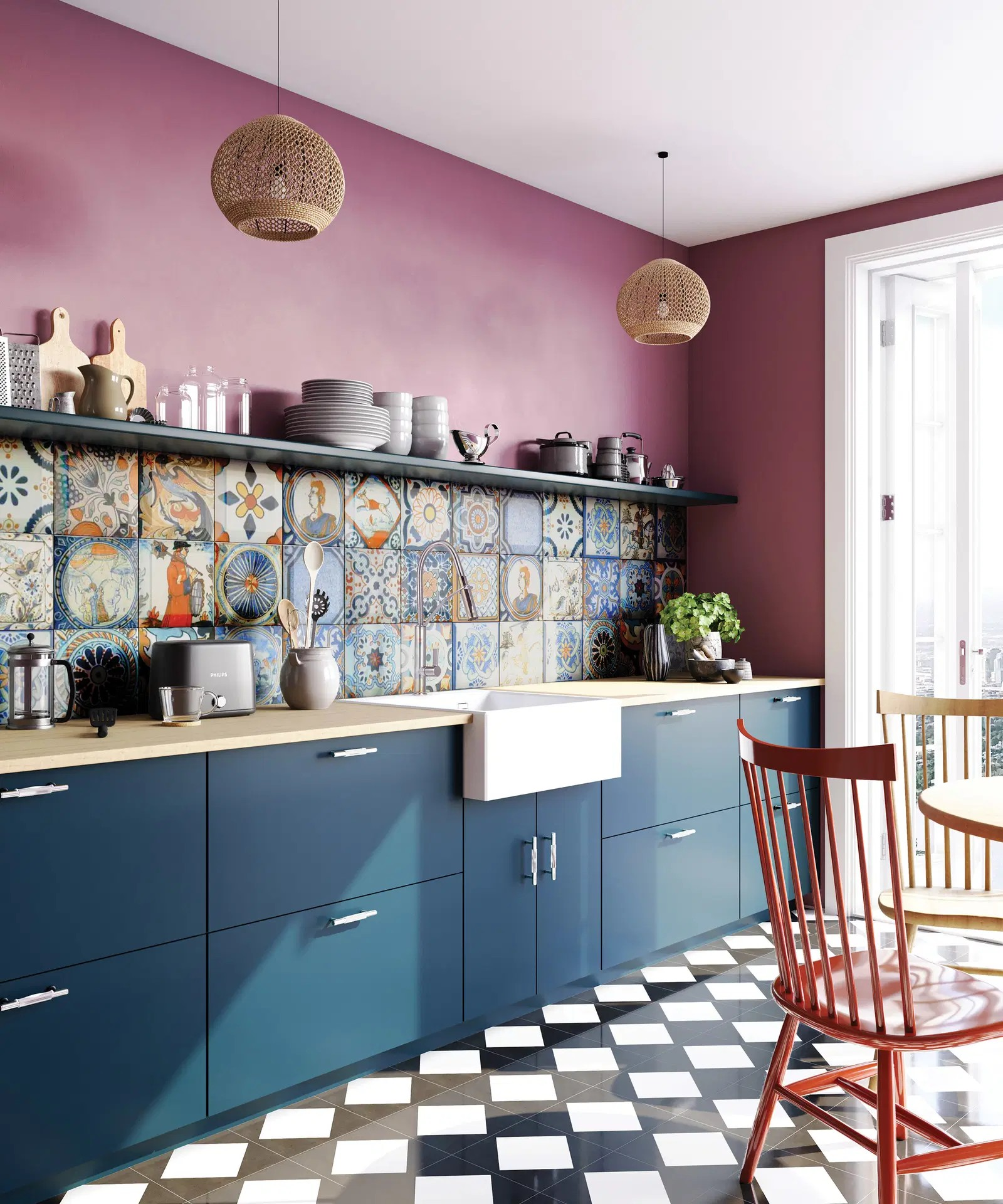 Erksavärviline köök siniste kappide, mustvalge ruudumustrilise põranda ja mustritega plaaditud tagaseinaga, mille keskmes on valge Deante valamuga tööpind.