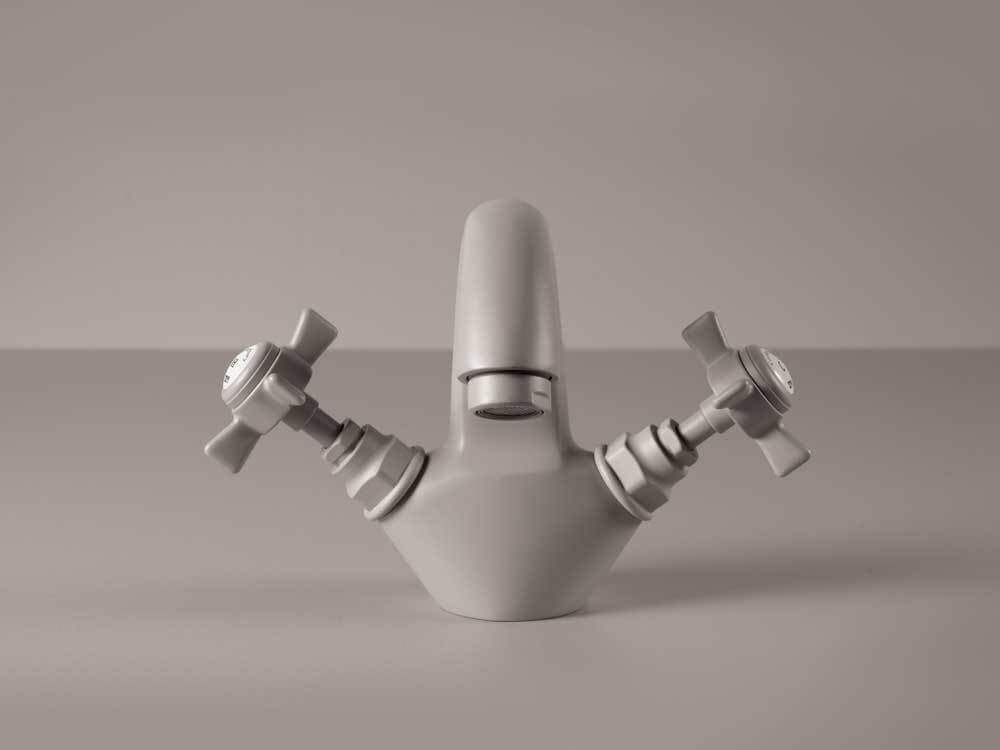 Klassikalise kujuga hall valamusegisti kahe keeratava ristkujulise nupuga, mis tähistavad sooja ja külma vett.