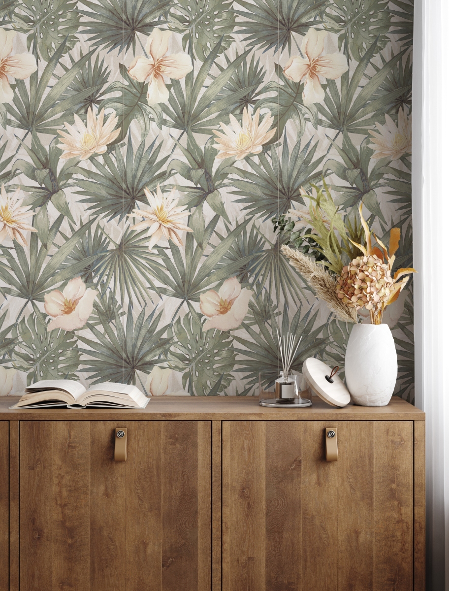 Troopilise mustriga tapeet, millel on rohelised palmilehed ja heledad õied, loob looduslähedase tausta. Selle ees asetseb soe puitkapp, millel on nahast käepidemed. Kapil lebab lahtine raamat ning valge vaas kuivatatud lillede ja arooma difuuseriga lisavad hubasust ja dekoratiivsust.