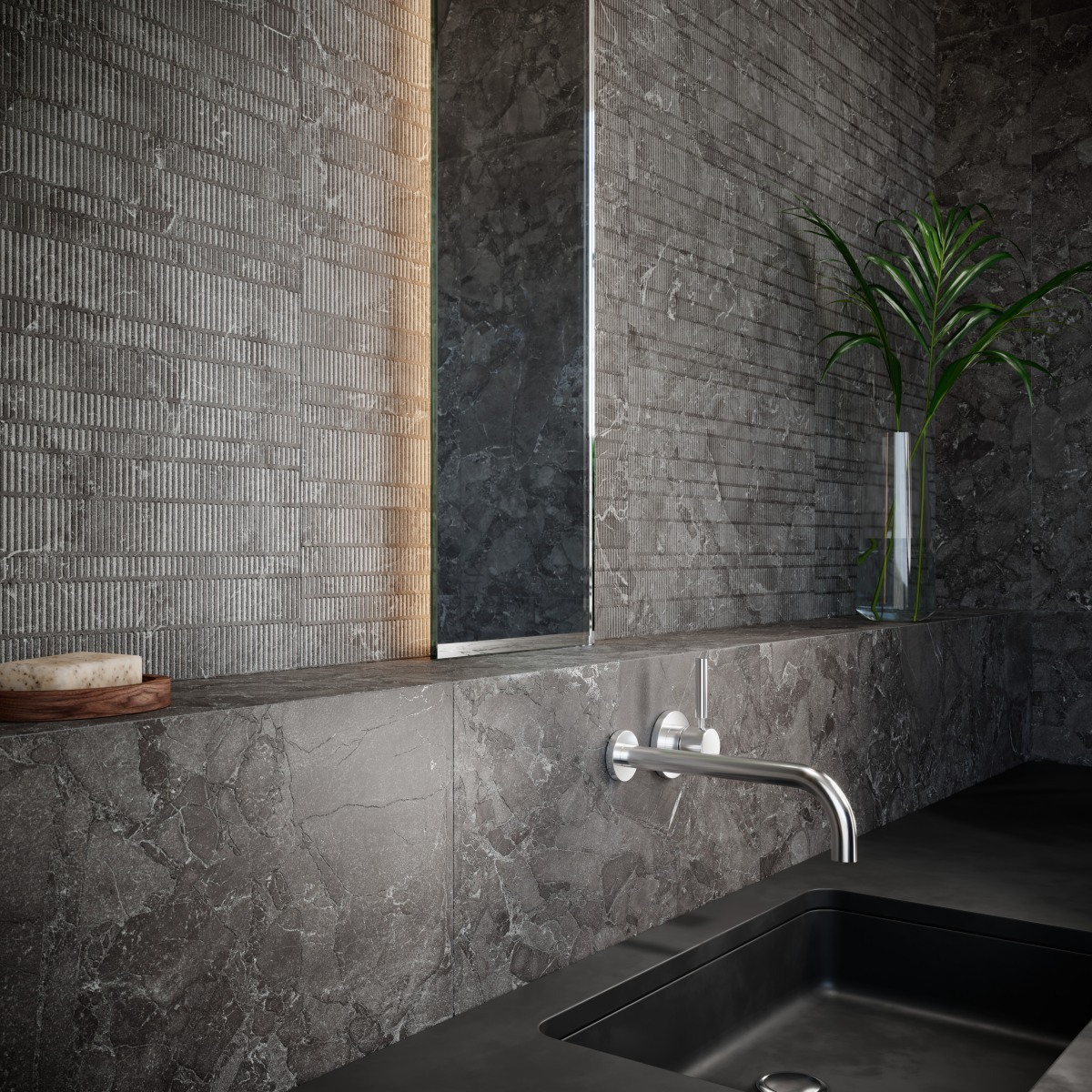 Tumedates toonides vannituba, kus seintel ja töötasapinnal on hallid kivimustrilised plaadid ning ribiline dekoor. Minimalistlik kraanisegisti ja modernne valgustus.