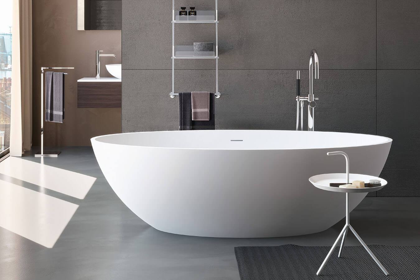 Minimalistlik vannituba valge eraldiseisva vanni ja tumeda seinapaneeliga. Elegantne segisti ja lihtne disainlaud lisavad stiili.