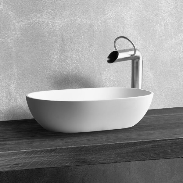 Minimalistlik valge ümar kausivalamu koos ainulaadse roostevabast terasest segistiga musta tamme tööpinnal – lihtne ja stiilne lahendus modernsesse vannituppa.