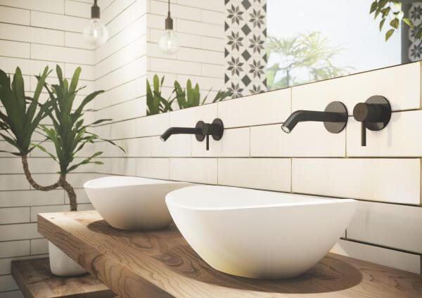 Minimalistliku disainiga valged valamud puidust tööpinnal loovad loodussõbraliku ja rahuliku vannitoaõhkkonna. Seinasegisti ja rohelus lisavad modernset värskust.