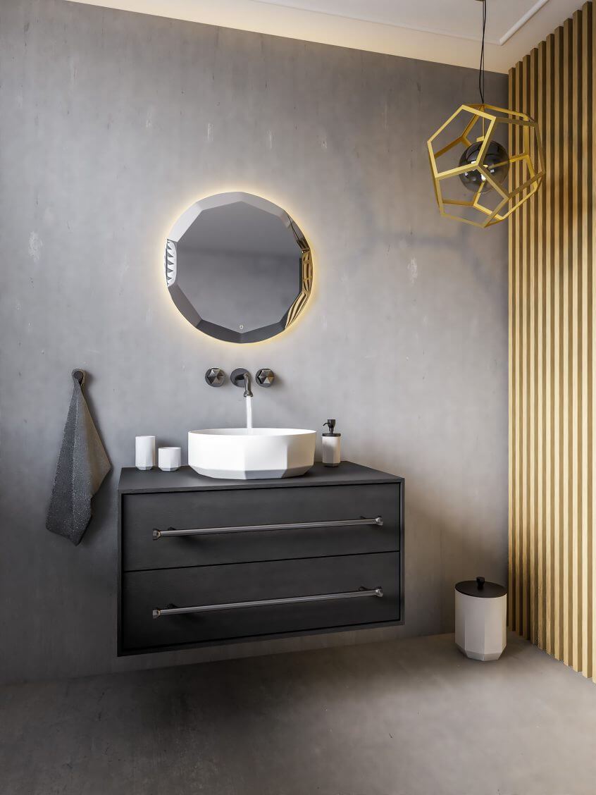 Stiilne vannitoamööbel koos geomeetrilise peegli ja valge tööpinnale paigaldatava valamuga, millele lisavad iseloomu seinale kinnitatud segisti ja kuldne ripplamp.