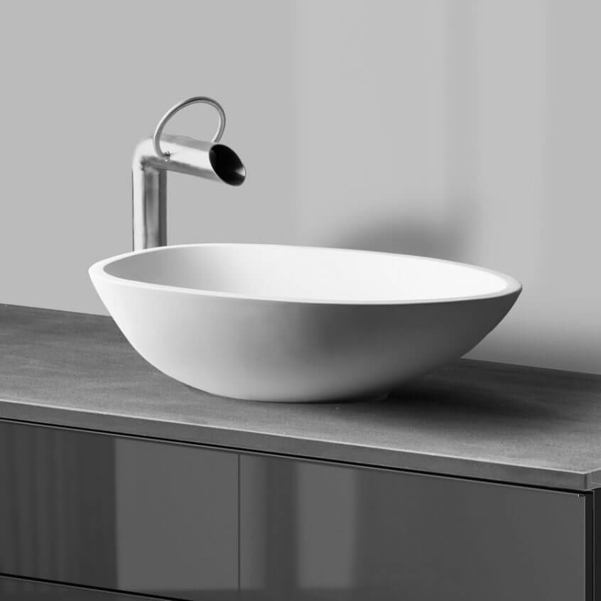 Elegantne valge tööpinnale paigaldatav valamu koos modernse kaarja segistiga toob vannituppa minimalistliku ja stiilse ilme.