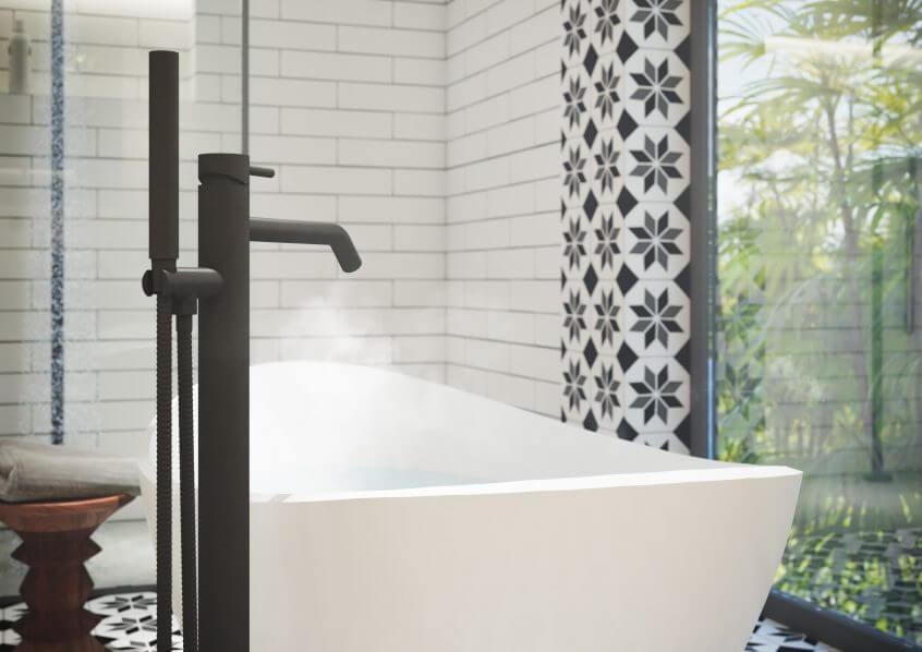 Valge vaba­seisev vann koos mattmusta põrandasegisti ja mustvalge mustritapeediga loob elegantse ja rahuliku spaalaadse vannitoa interjööri.