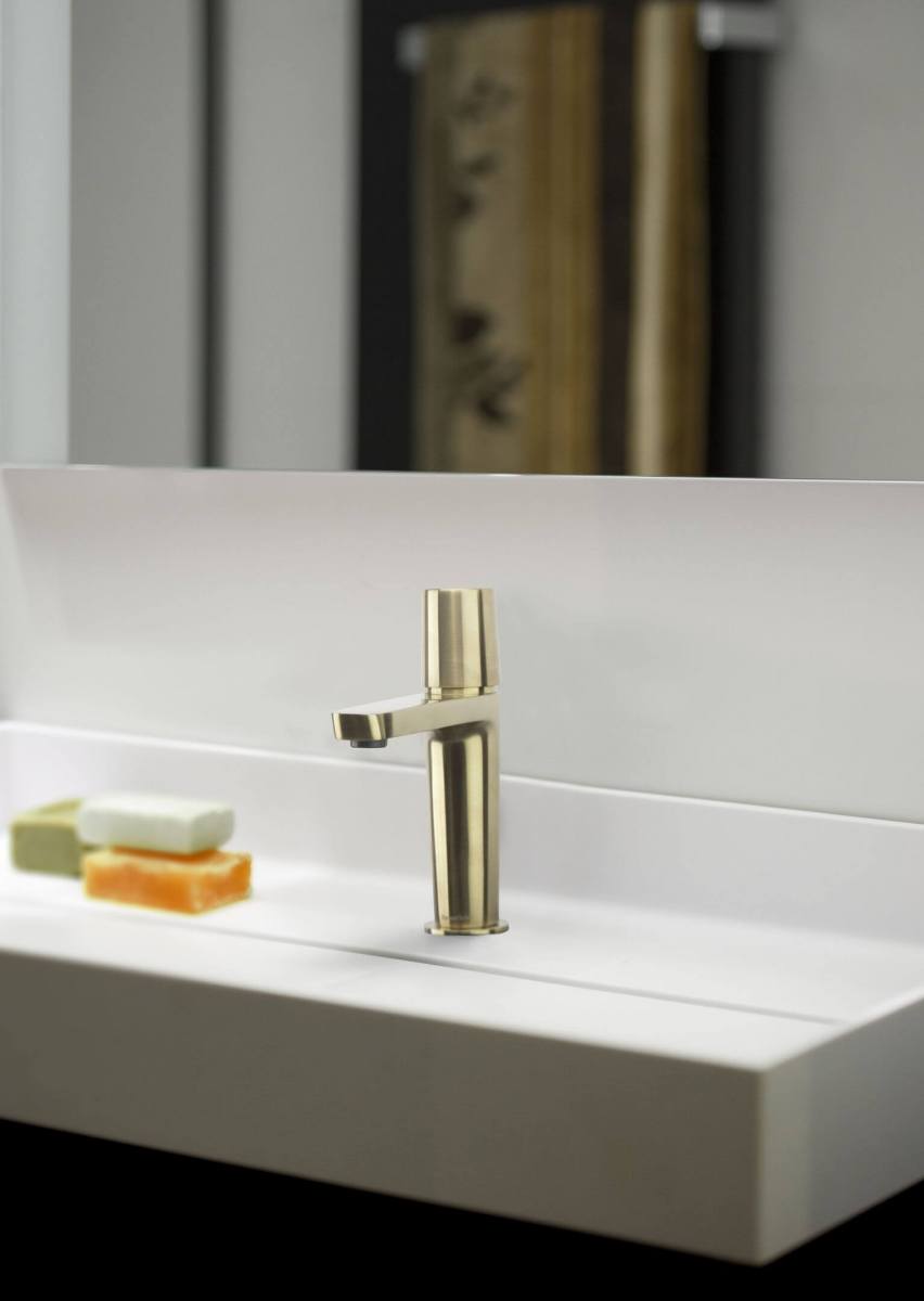 Messingiv&auml;rvi kraan valge valamu peal koos seebit&uuml;kkidega.