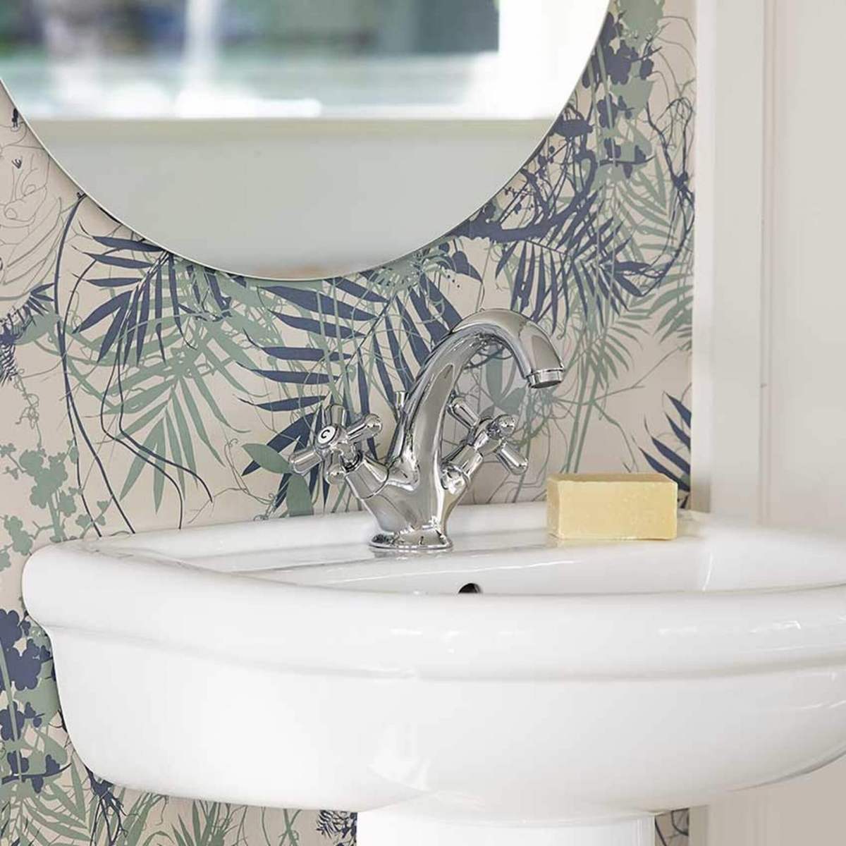 Retrosegisti valgel vannitoavalamul troopilise mustriga tapeedi taustal.