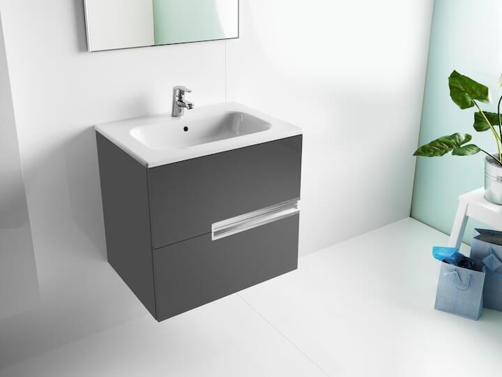 Hall kraanikauss kapp ja peegel vannitoas, kõrval taim ja sinine kingituste kott.