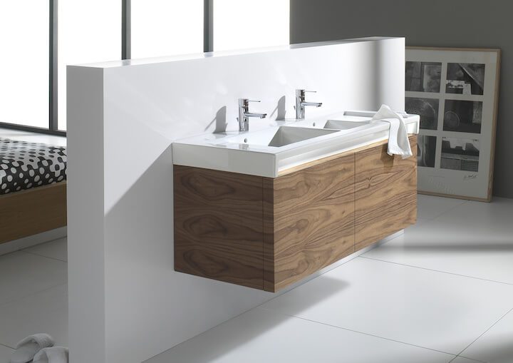 Topelt kraanikauss puidust kappide ja valge seina taustal, kõrval suur aknaava ja mustvalge kunstiteos.