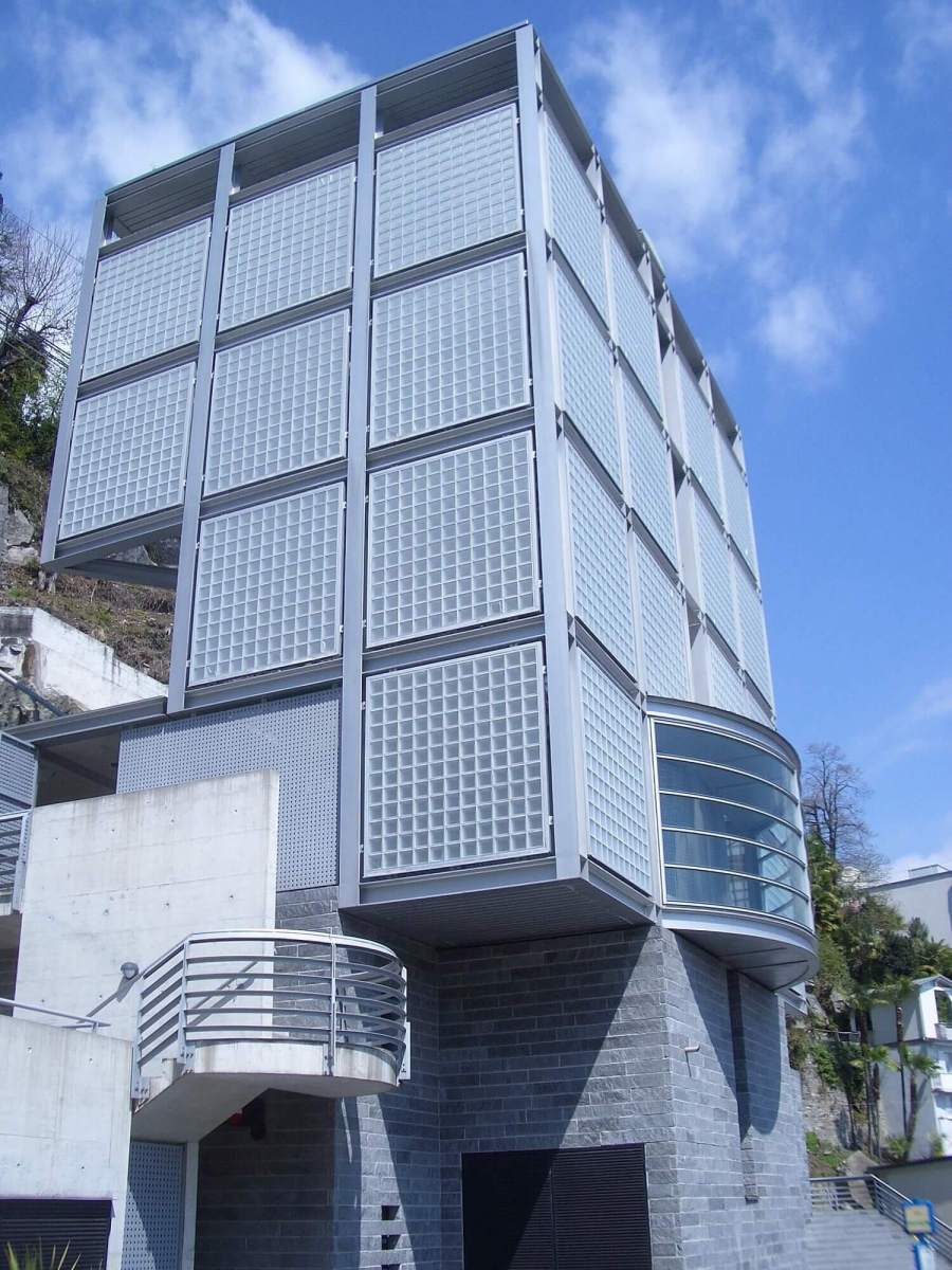 Hoone välisfassaad, millel on klaasplokid ja metallist konstruktsioon, millel on ümar aknasein.