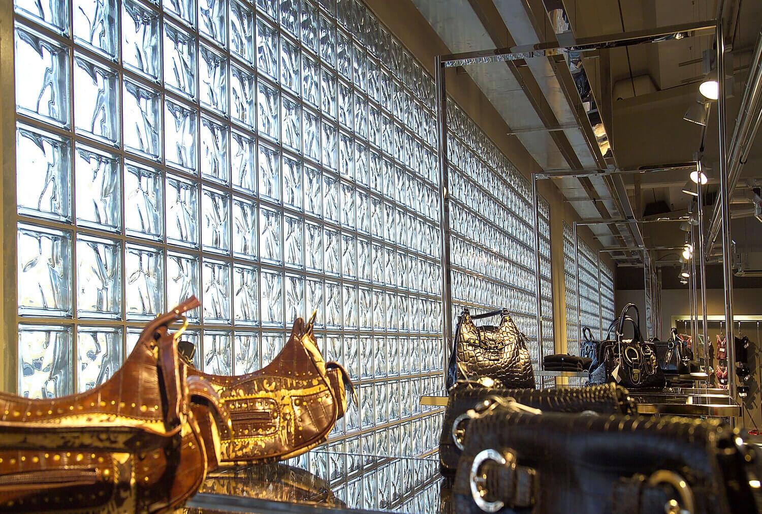 Klaasplokkidest sein, mille ees on mustad nahk-kotid riiulitel, kaubanduspinna interjöör.