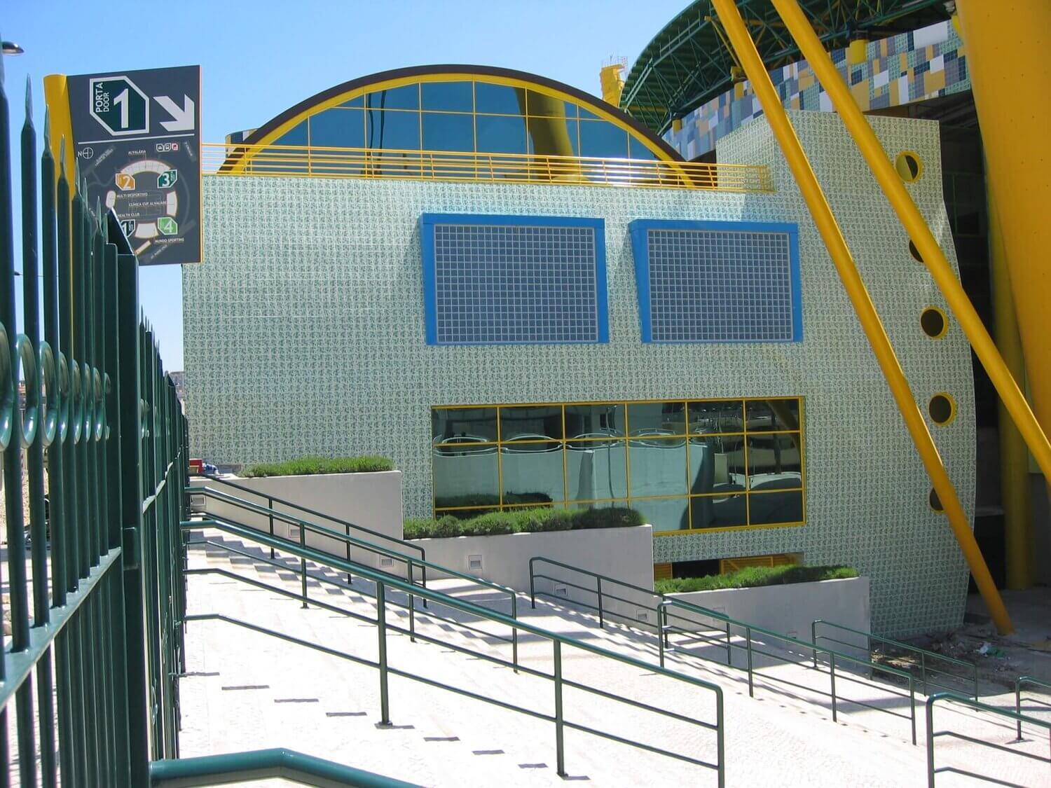 Klaasplokkidega kaetud hoone fassaad, millel on sinised aknad ja kollased detailid.