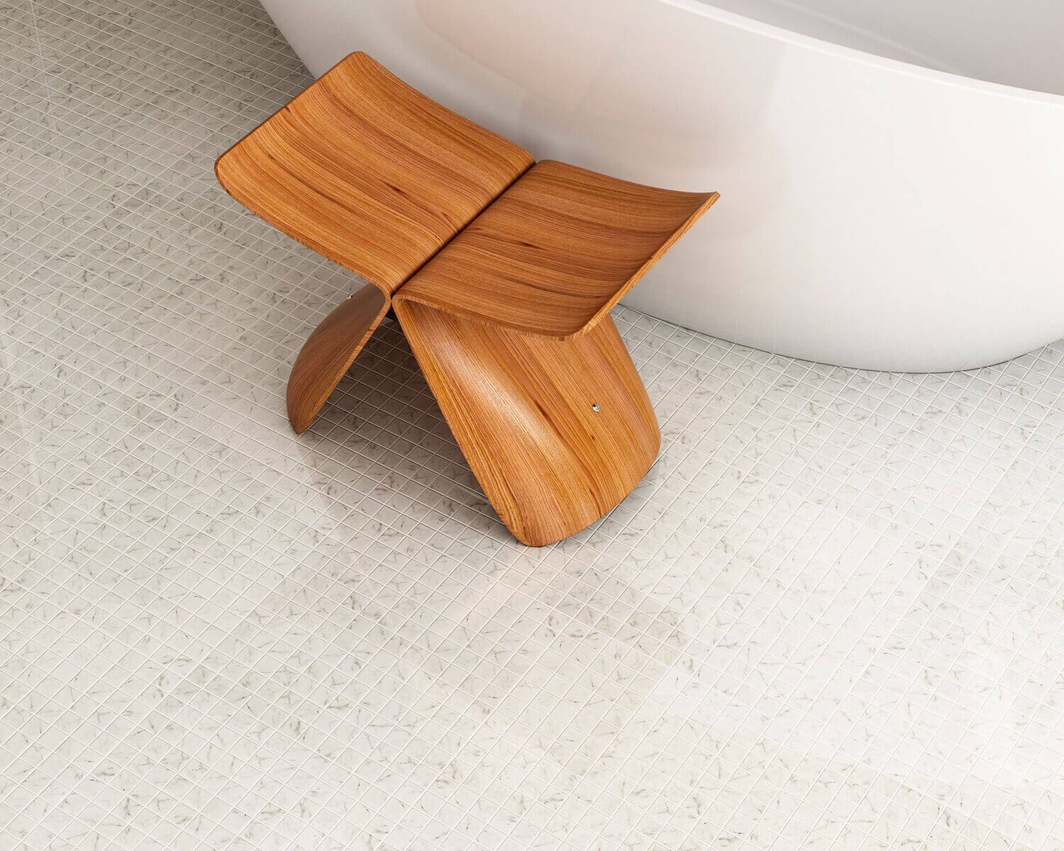 Hele vannitoap&otilde;rand v&auml;ikeste ruudukujuliste plaatidega, puidust tool ja valge vann.