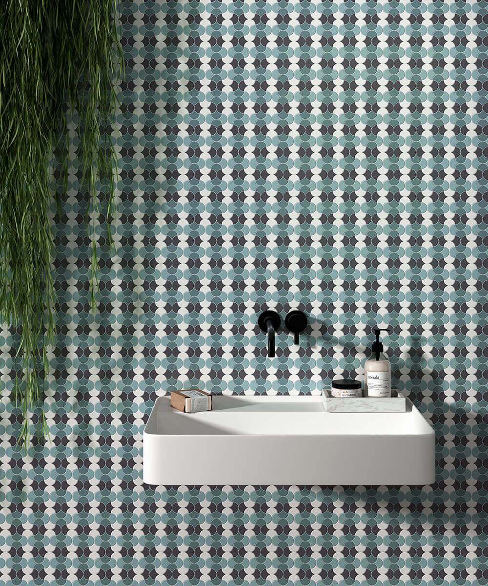 Sein vannitoas sinise ja valge mustriga mosaiikplaatidega, valge valamu ja must segisti.