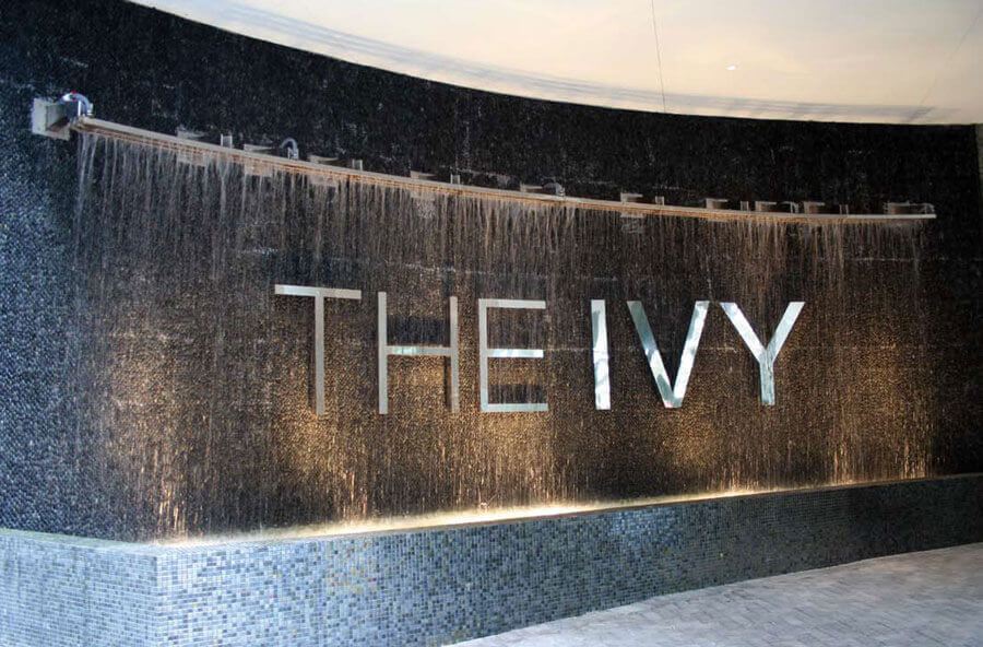 Tume mosaiikseina taustal veekardin, mille keskel metallist kiri 